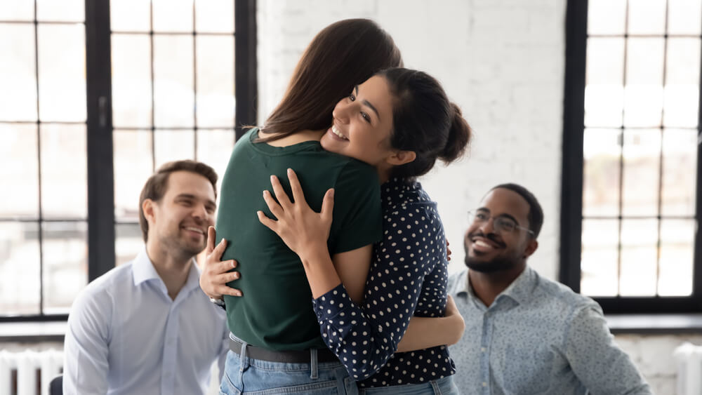 What is Wet Brain? 2 Woman hugging each other with their happy male friends