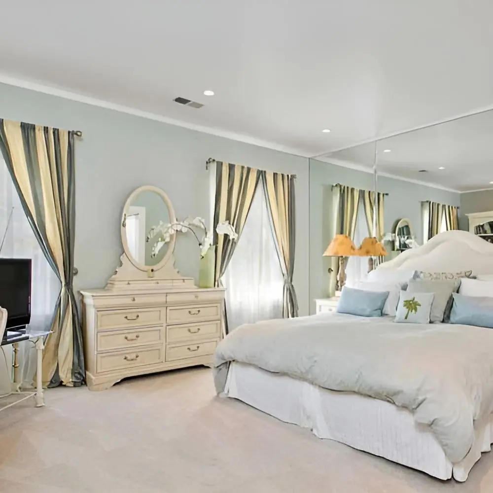 Photo of Safe Haven Recovery's luxury rehab private suites, showing a beautiful king bed with fine linens, elegant curtains, and high end furniture