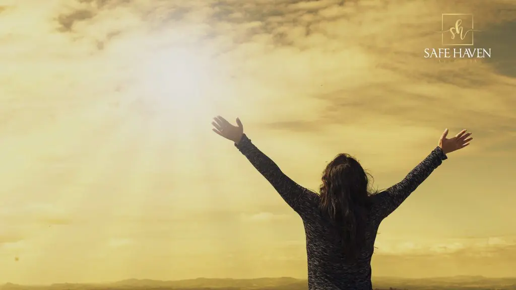Woman raising both of her arms under the sun