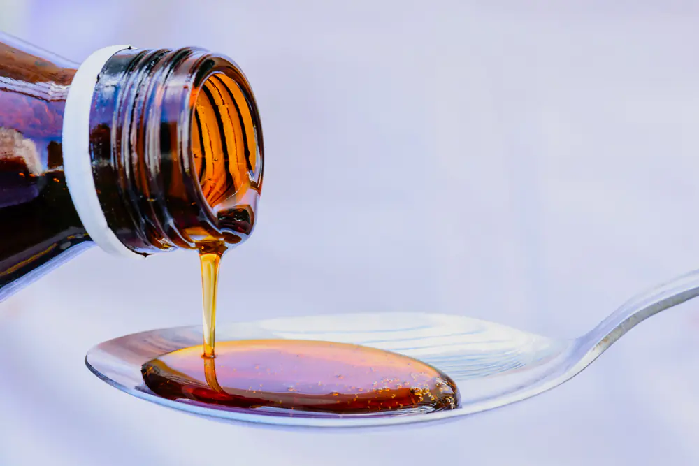 hand pouring medication or antipyretic syrup