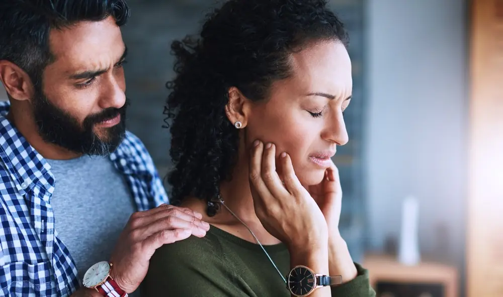 Man comforting distressed woman, illustrating quotes about loving someone in addiction with emotional support.