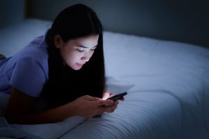 Young girl reading quotes on her cellphone