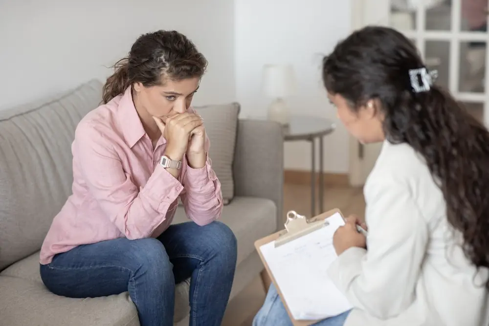 woman in addiction recovery talking to addiction treatment professional for managing cravings