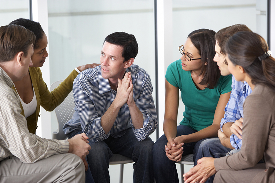 Alcohol Addiction Treatment in Beverly Hills, CA 4 Support group sitting in a circle, listening to a man share his experience with alcohol abuse during a therapy session.