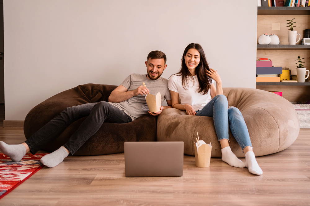 Mental Health Treatment in Beverly Hills, CA 3 A cheerful couple relaxes on large beanbag chairs, facing a laptop on the floor.