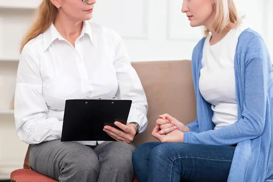 A female therapist engaged in addiction counseling with a client during a session