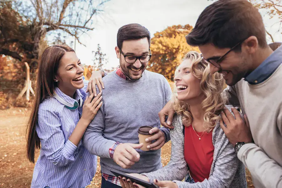 group of friends laughing together outdoors symbolizing positive connection after whippets addiction recovery