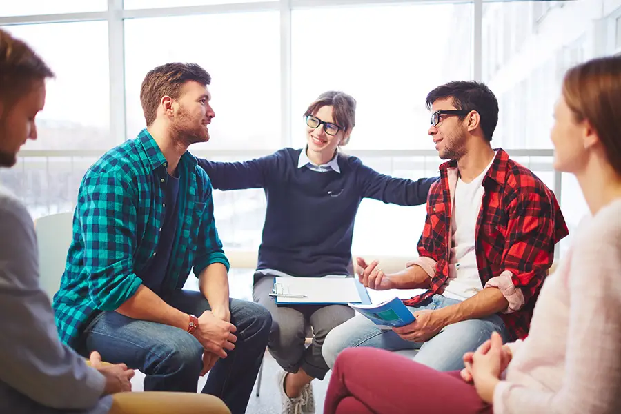 group therapy session where people discuss challenges and recovery related to opioid abuse