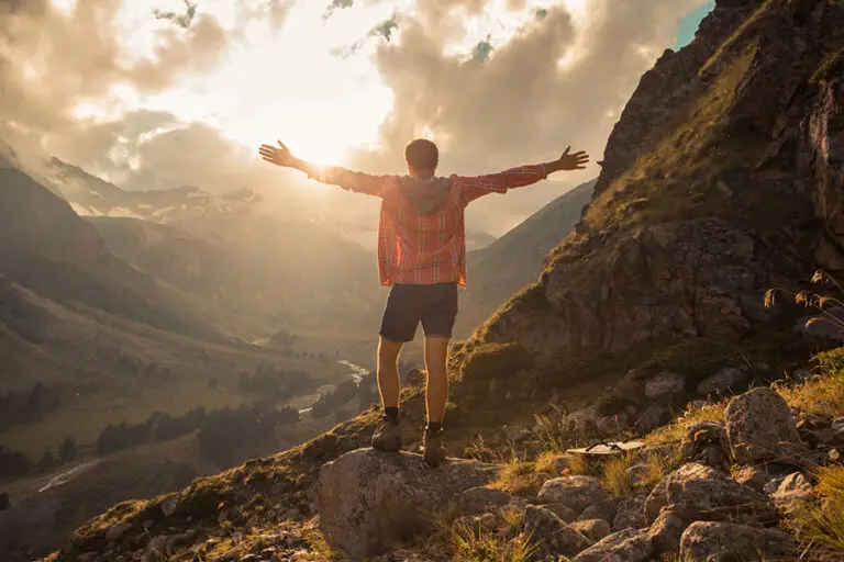 person standing with arms raised in nature at sunrise, symbolizing recovery from whippets drug abuse and new beginnings.