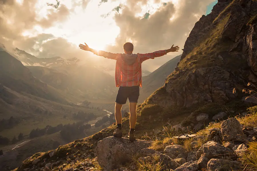 Person standing with arms raised in nature at sunrise, symbolizing recovery from whippets drug abuse and new beginnings.
