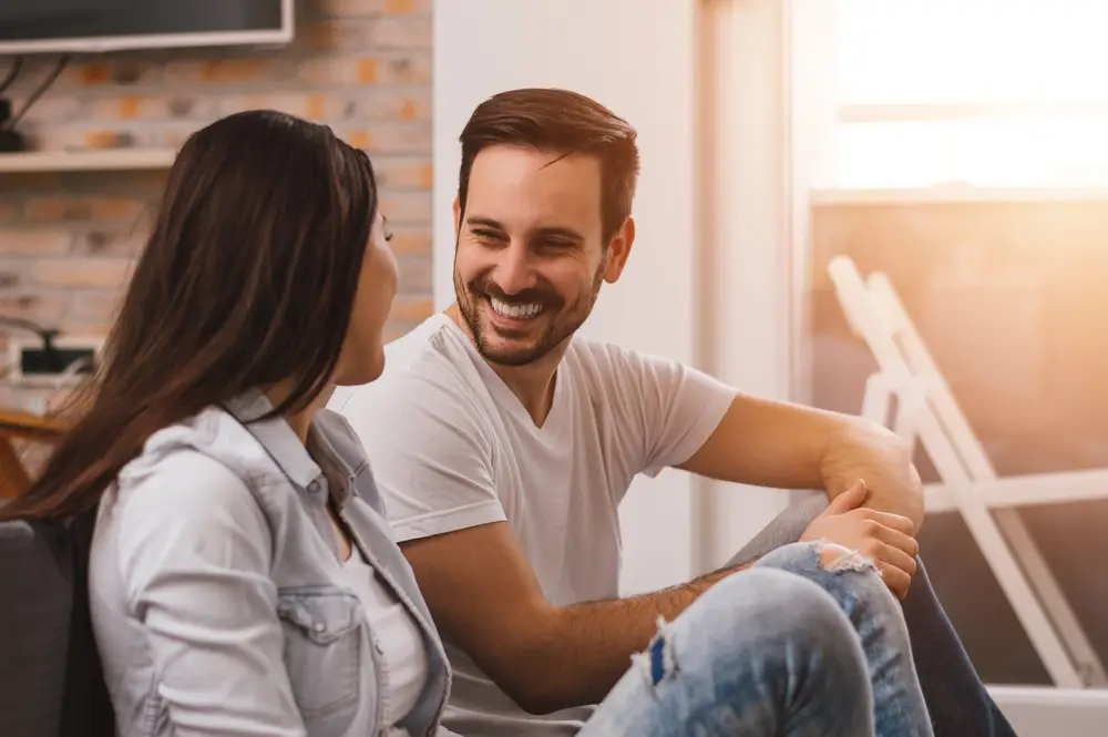 smiling couple having a conversation about coping with mental health.