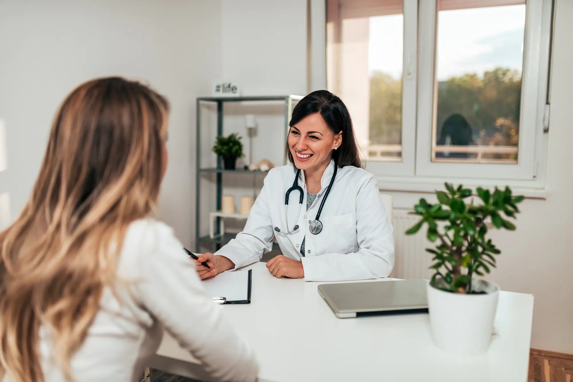 beautiful young female medical staff smiling while talking to her patient about luminare health plans for rehab