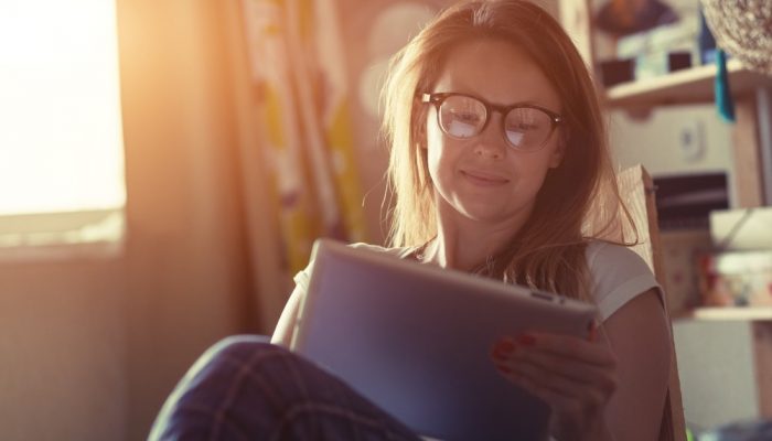 a woman wearing eyeglasses reading thanksgiving addiction recovery quotes while sitting in a chair