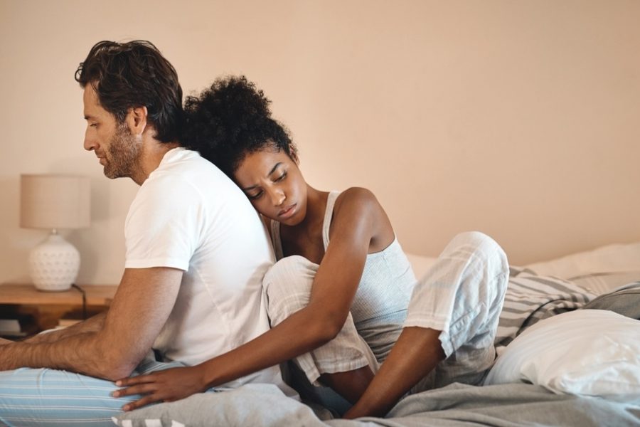 Couple sitting back-to-back in bed, expressing emotion for drug addiction quotes for loved ones. Couple sitting back-to-back in bed, expressing emotion for drug addiction quotes for loved ones.