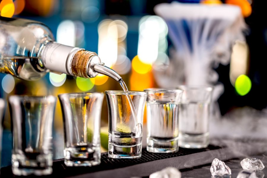 Liquor being poured into shot glasses at a bar, raising the question how many shots can you take to get drunk. Liquor being poured into shot glasses at a bar, raising the question how many shots can you take to get drunk.